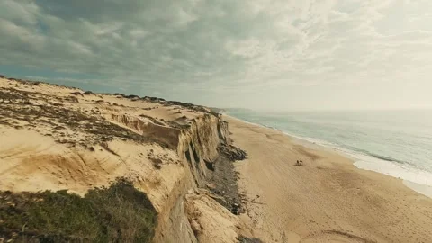 Aerial view of rugged cliffs meeting sandy beach Stock Footage 340226331