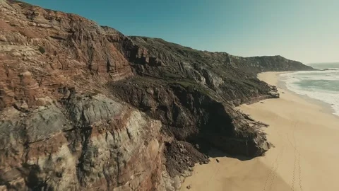Aerial view of rugged cliffs meeting turquoise sea Stock Footage 341823673