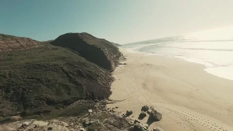 Aerial view of rugged cliffs meeting sandy beach Stock Footage 341824364