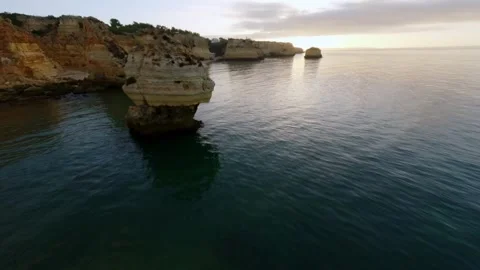 Aerial view of rugged cliffs meeting tranquil ocean at dusk 스톡 동영상 346091697