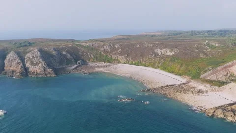Aerial view of the rugged cliffs, rocky coastline, and sandy beach of Cap dErquy Stock Footage 346717712