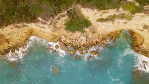 Aerial view of rugged coastline with clear turquoise sea water on a sunny day Stock Footage 344752553