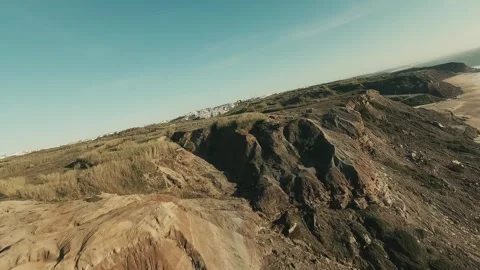 Aerial view of rugged coastline meets sandy beach Video stock 341826734