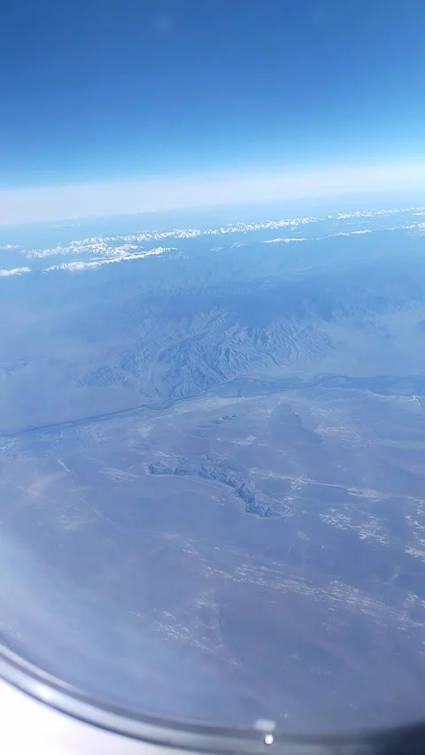 Aerial view of rugged mountain terrain and valleys beneath a clear blue sky, Stock Footage 338287573