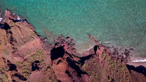 Aerial View of Rugged Red Volcanic Coastline and Clear Blue Ocean Stock Footage 304089228