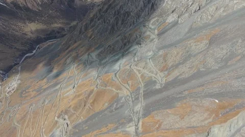 Aerial view of rugged terrain showcasing winding paths and textures Video stock 321398310