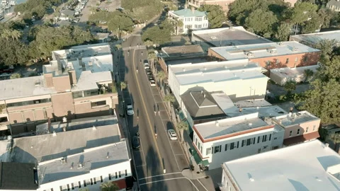 Aerial view of runners running down street of small town Stock Footage 163239555