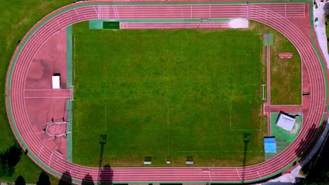 Aerial view of a running track and sports field with vibrant green grass Stock Footage 293313629