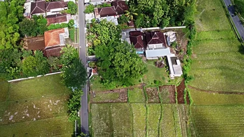 Aerial view of a rural area featuring a road, houses, and green fields. The.. Stock Footage 281153323
