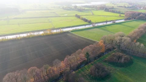 Aerial view of rural fields divided by hedgerows canal and scattered trees Stockbeeldmateriaal 323011691