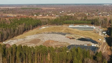 Aerial View of Rural Garbage Dump Surrounded by Forest and Dirt Roads Stock Footage 305461609