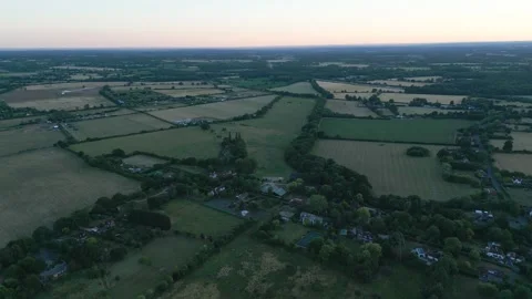 Aerial view of a rural landscape with fields, trees, and houses, under a pa.. Stock Footage 340473987