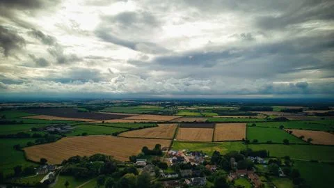 Aerial view of a rural landscape with patchwork fields under a dramatic clo.. Photos