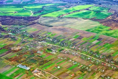 Aerial view rural landscape with patchwork agricultural fields, tiny houses Stock Photos