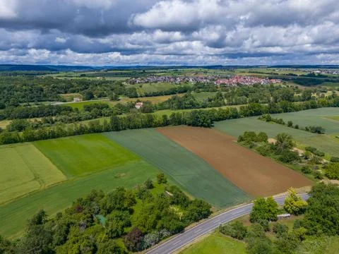 Aerial View of Rural Landscape with Patchwork Fields and Village Under Clou.. Stock Photos