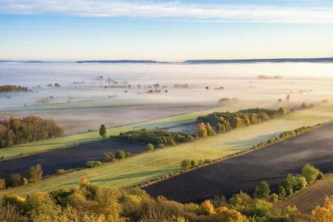 Aerial view at a rural patchwork landscape with morning fog and beautiful autumn 스톡 사진