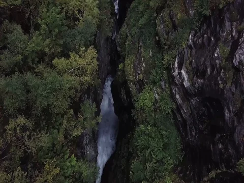 Aerial View of Rushing Waterfall through Deep Epic Valley of Rock and Forest Stock Footage 82981228