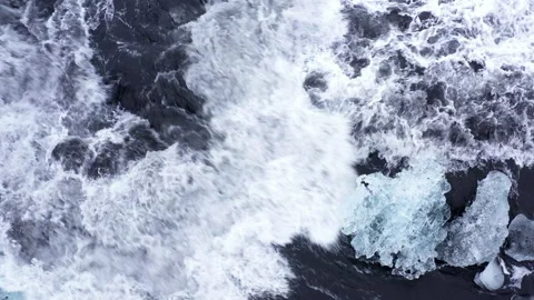 Aerial View Of Rushing Waves Hitting Icebergs Video stock 233452393