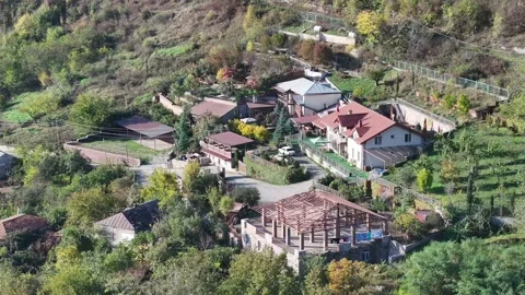 Aerial View of Rustic Homes in a Green Mountain Landscape Stock Footage 341894178