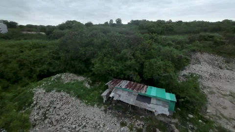 Aerial View of Rustic Shack Amidst Lush Green Landscape in Bali Stock Footage 337420529