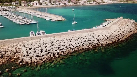 Aerial view, a Sailboat sails in a small marina in a sunny summer day Stock Footage 112213801
