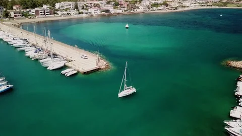 Aerial view, a Sailboat sails in a small marina in a sunny summer day Stock Footage 112390498