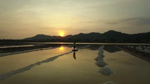 Aerial view of salt worker gathering salt on the salines, Cambodia Stock Footage 83535248
