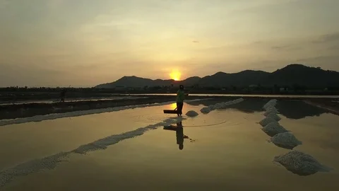 Aerial view of salt worker gathering salt on the salines, Cambodia Stock Footage 83535262