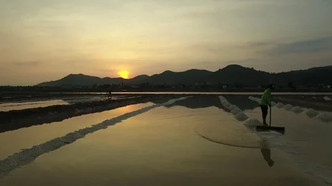 Aerial view of salt workers gathering salt on the salines at sunset - Cambodia 動画素材 83535271