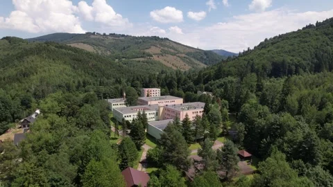 Aerial view of sanatorium building complex in forested mountains Stockbeeldmateriaal 347859686