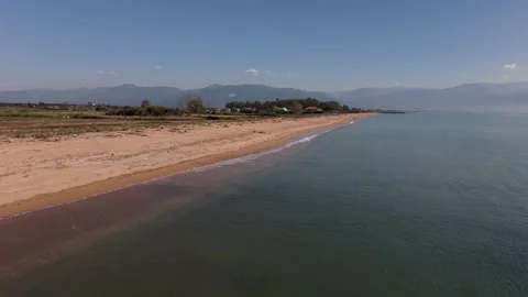 Aerial View of Sandy Beach and Calm Sea With Mountains in Greece Stock-Footage 330956693