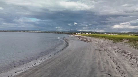 Aerial view of sandy beach and coastal fields under dramatic sky 스톡 동영상 332680024