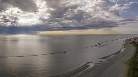 Aerial view of sandy beach and stormy sky with sun rays piercing the clouds Foto stock