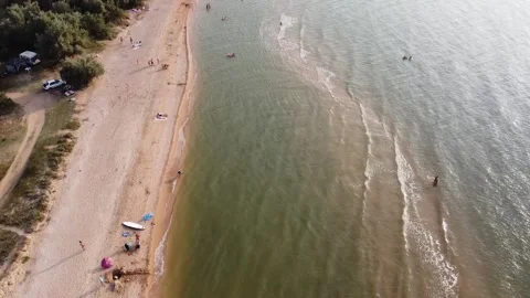 Aerial view of sandy beach during golden hour. Dolly and tilt up. Stock Footage 164453511