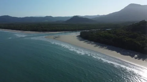 Aerial view of sandy beach next to a rainforest with a river and mountains Stock Footage 284217895