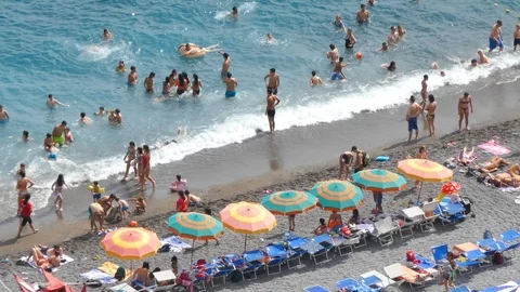 Aerial view of sandy beach with rows of umbrellas, swimming people in sea Italy Stock Footage 112816264