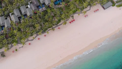Aerial view of the sandy beach with villas, palms near the clear sea. Stock Footage 103290616