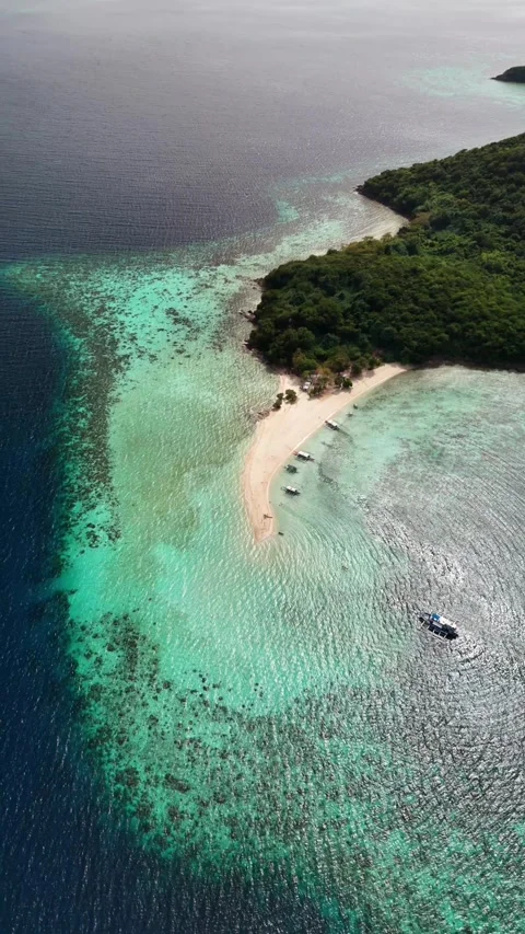 Aerial view of sandy island spit, coral reef drop off, and boats in Philippines Stock Footage 341999771