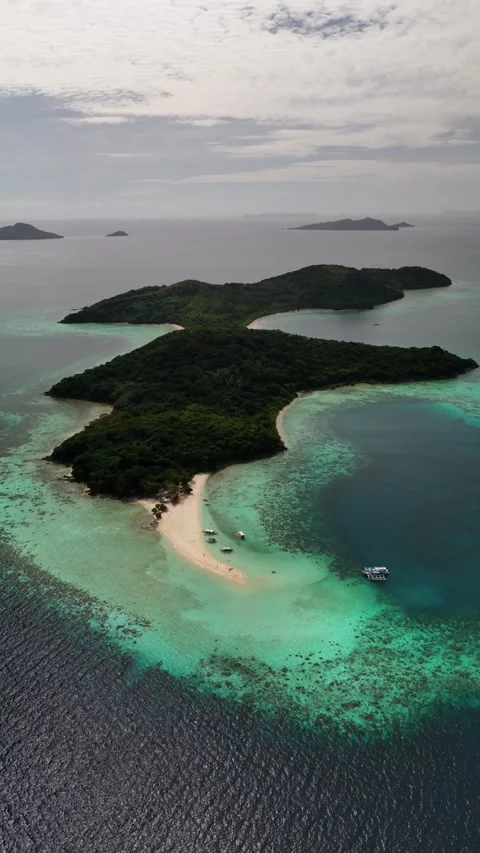Aerial view of sandy island spit, coral reef drop off, and boats in Philippines Stock Footage 341999833