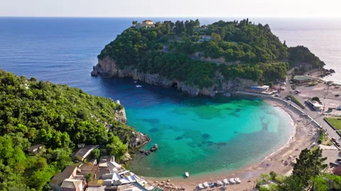 Aerial view of sandy shore with crystal clear waters by lush greenery. Stock Footage 260193196