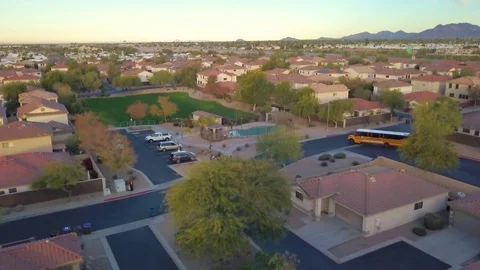 Aerial view of school bus pulling up to pickup kids in their neighborhood Stock Footage 101711938