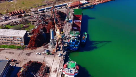 Aerial view of scrapyard crane loading cargo ship, port Stock Footage 343843626