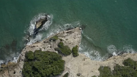 Aerial view of the sea breaking waves on the rocks on a sunny day. Zoom out 스톡 동영상 168747441