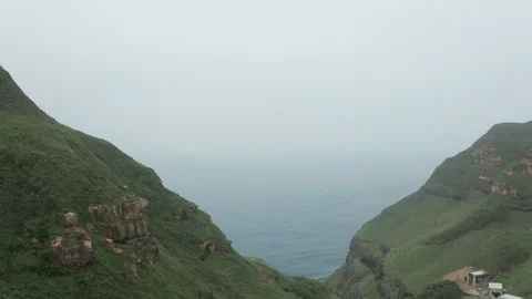 Aerial view of the sea going through 2 sections of Bitoujiao moutain Stock Footage 104809187