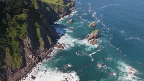 Aerial view of sea stacks beneath green coastal cliffs Stockbeeldmateriaal 343324220