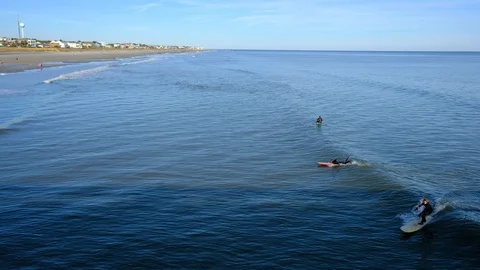 Aerial view of sea surface and surfers on it. Summer beach panoramic view Stock Footage 101929290