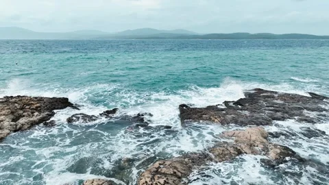 Aerial view of sea waves hitting the rocks with drone Video stock 255613042