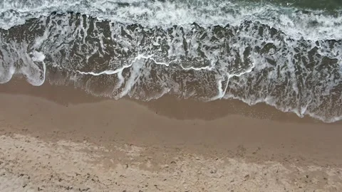 Aerial view of sea waves rolling on a sandy beach in clear weather Stock Footage 144623559