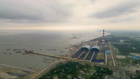 Aerial view of a seaside coal-powered power plant under a vibrant, cloud-filled  Video stock 287777375