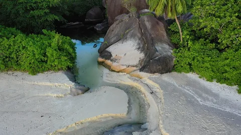 Aerial view of a secluded Seychelles beach with a river and mountains 動画素材 129404576